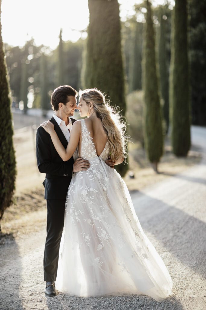 Romantico sguardo tra gli sposi nel viale dei cipressi