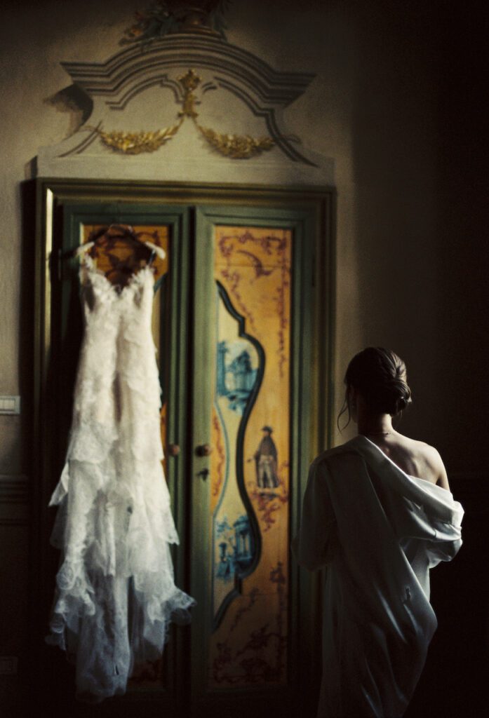 La sposa osserva il suo abito in una camera di hotel